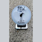 Front view of the Lady Luck resin shifter ball on a shifter — gloss white resin with vintage pinup girl artwork in black, holding a flower and wrench, with 'Lady Luck' banner below. Crystal-clear resin dome finish.
