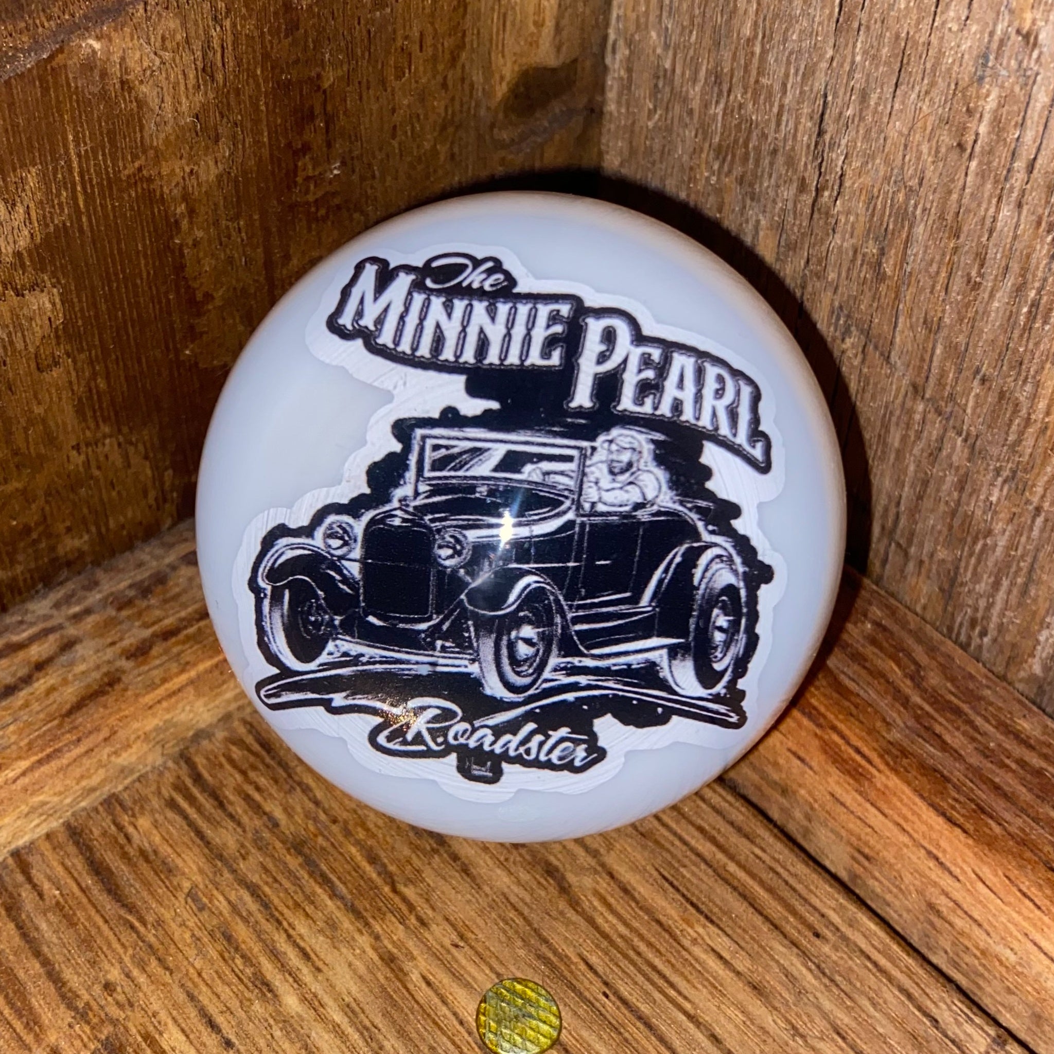 Front view of the Minnie Pearl Resin Shifter Ball in white, showing the 1928 Ford Roadster hot rod graphic with The Minnie Pearl Roadster text in black ink sealed under a crystal-clear dome